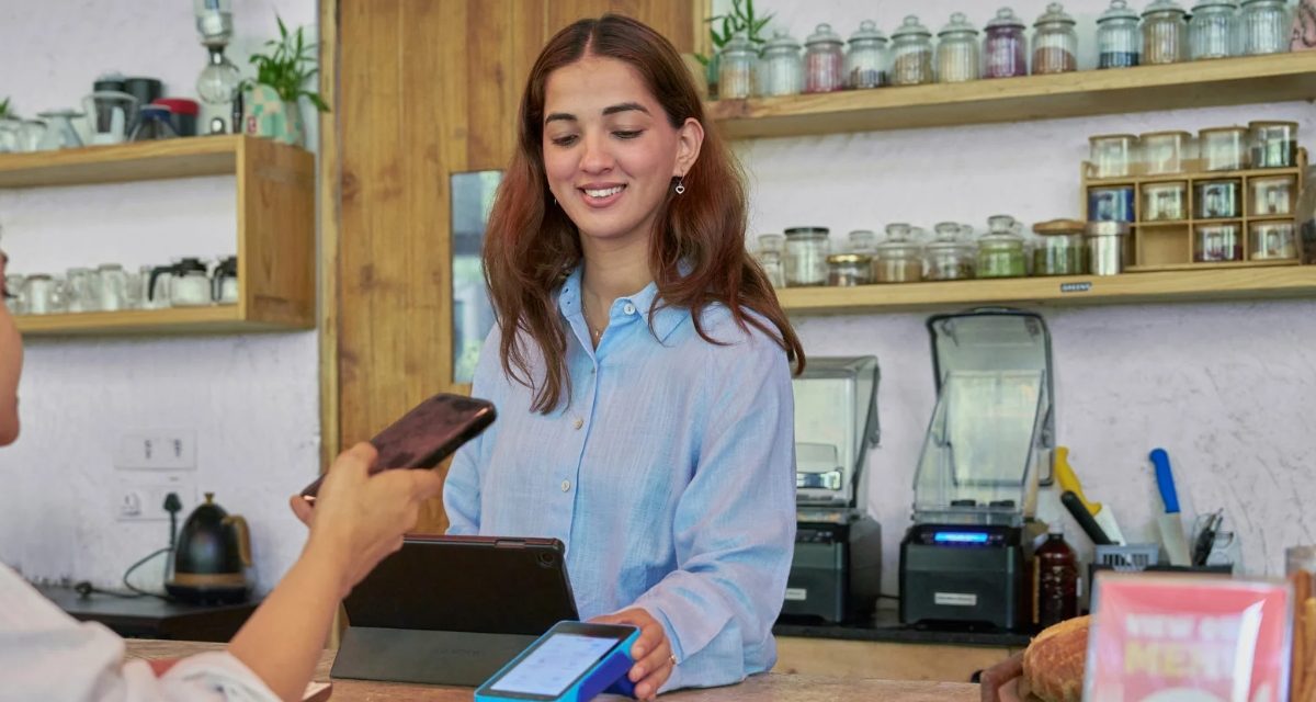 Pedagang menerima pembayaran digital menggunakan kode QRIS di tokonya