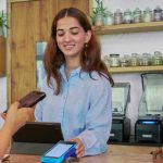 Pedagang menerima pembayaran digital menggunakan kode QRIS di tokonya