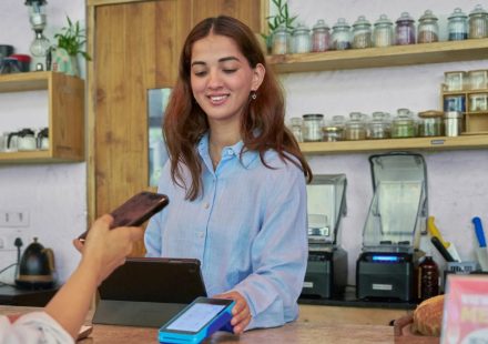 Pedagang menerima pembayaran digital menggunakan kode QRIS di tokonya