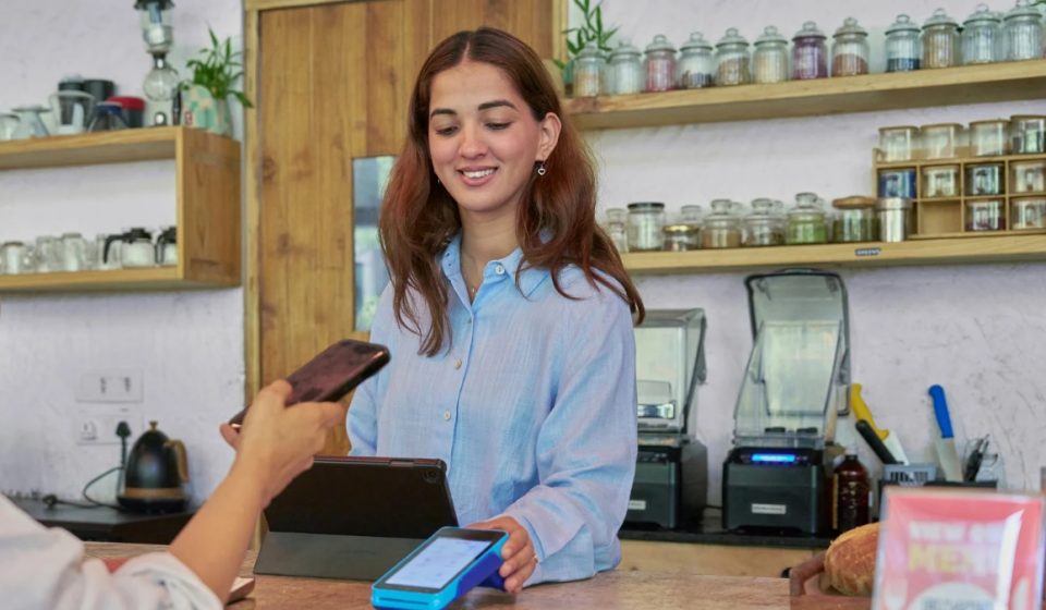 Pedagang menerima pembayaran digital menggunakan kode QRIS di tokonya
